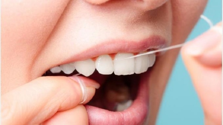 Mencegah gigi berlubang dengan menggunakan dental floss, Sumber: tribunnews.com