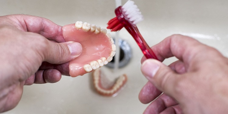 Ilustrasi membersihkan gigi palsu, Sumber: sehatq.com
